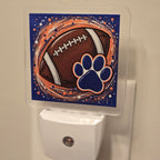 Frosted acrylic night light with a football and blue paw print on a blue and orange background, plugged into a wall outlet