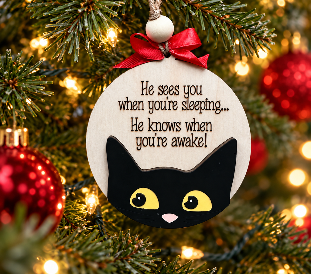 Black cat "He sees you when you're sleeping" layered wood Christmas ornament hanging on a lit Christmas tree, cut by Rise and Shine Gifts in Dothan, Alabama OR-030
