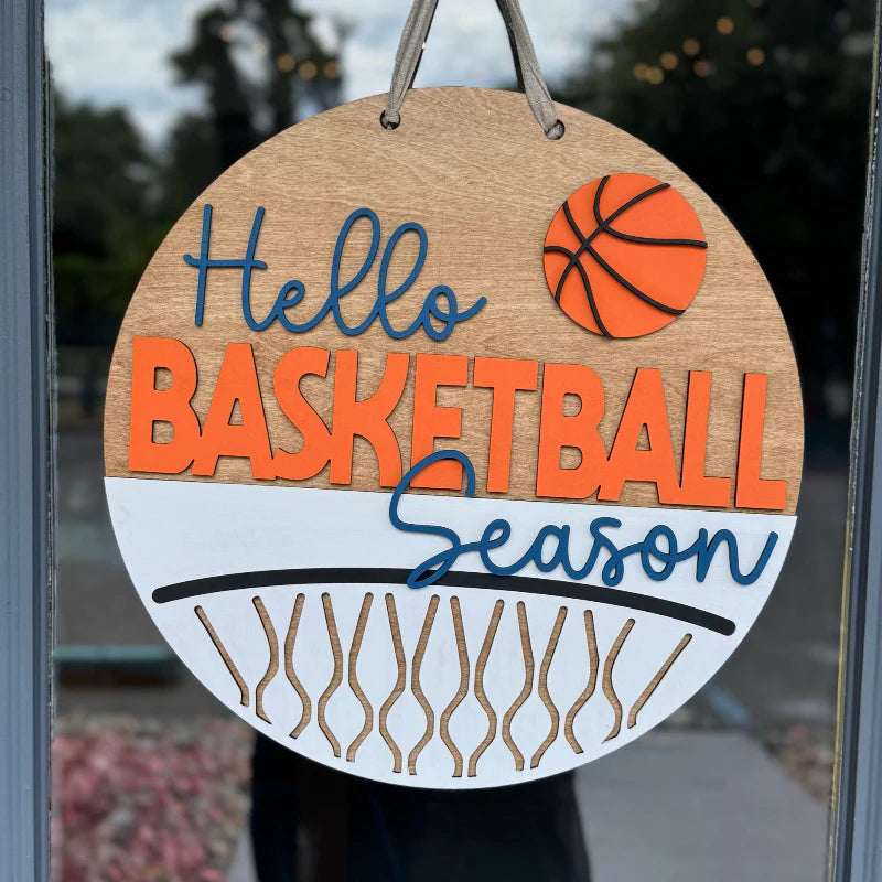 Decorative sign with 'Hello Basketball Season' text and a basketball graphic on a glass door. Handmade in Dothan, Alabama our high-quality DIY kits, home décor, and gifts are crafted with care. Join a workshop or create at home with our artisan-crafted designs! 
