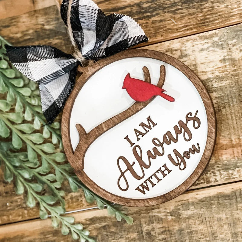 Decorative ornament with cardinal bird and text on a wooden surface.