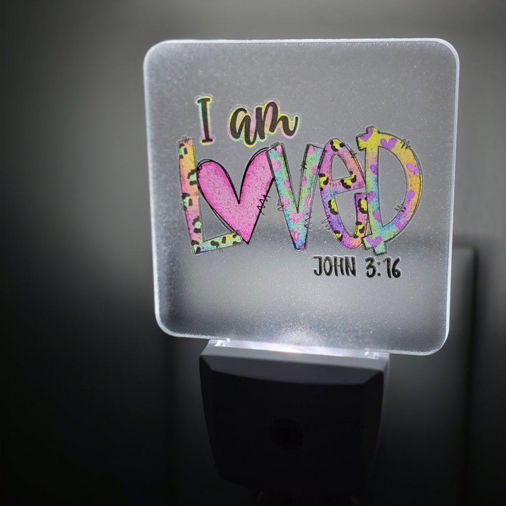 Frosted acrylic night light with a colorful heart and leopard print "I am Loved, John 3:16" design, glowing in a dark room