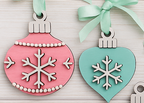 Set of eight retro-style layered wooden Christmas ornaments by Rise and Shine Gifts, shown with greenery and mint ribbons. DIY paint kit for Take & Make, craft parties, and pop-up events in Dothan, Alabama