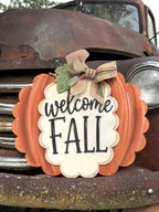Welcome Fall pumpkin door hanger with sage leaf and fall ribbon bow on a vintage rusty truck, cut by Rise and Shine Gifts in Dothan, Alabama - SHINE-DH-011