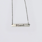 A collection of stainless steel bar necklaces with different motivational words engraved on them, displayed in silver, gold plated, and rose gold colors.
