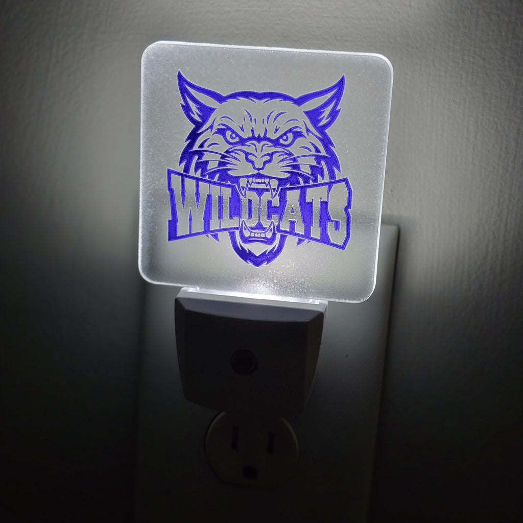 Frosted acrylic night light with a purple Wildcats mascot design, glowing in a dark room